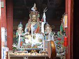 Lo Manthang Thubchen 05-2 Main Assembly Hall Guru Rinpoche Padmasambhava Statue I think the monk I met leaving morning prayers from the assembly hall of the Thubchen Gompa in Lo Manthang was surprised that I knew that the main statue was Guru Rinpoche (Padmasambhava). To the right of Padmasambhava you can see the left portion of a statue of Amitayus, the Buddha of long life. The monk asked me to take a photo of the statue, which I think turned out quite nicely despite the low light. I showed the monk the photo and we both smiled and embraced. A magic moment.